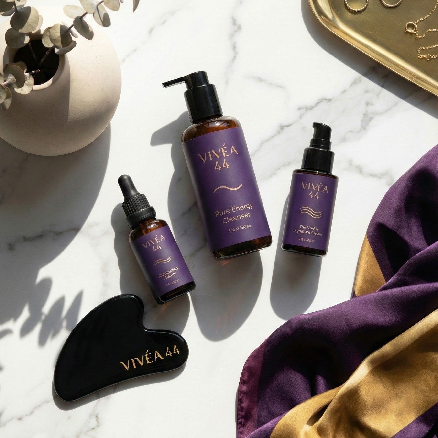 Vivea 44 skincare products on a marble surface with decorative elements.