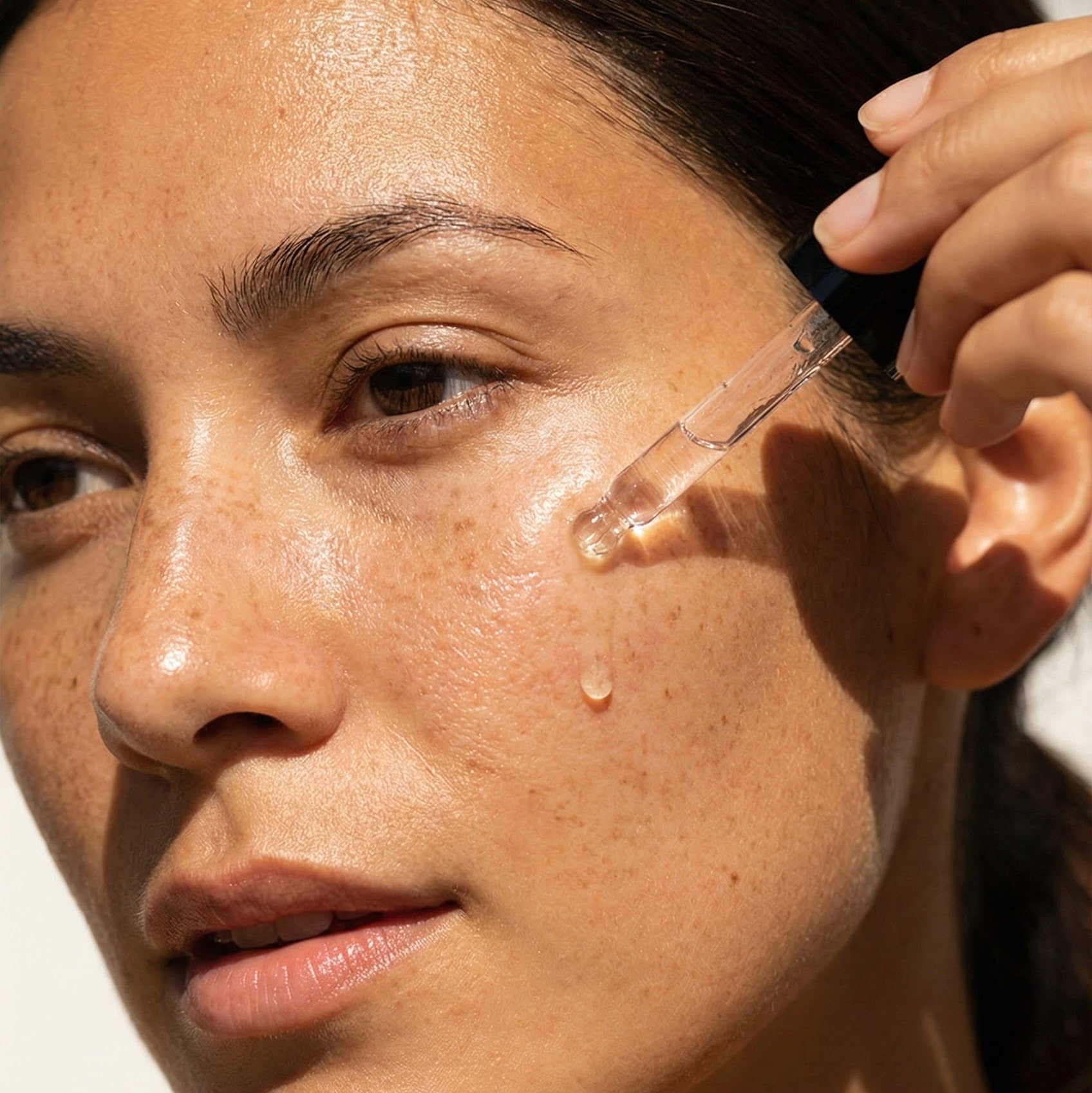 Woman applying the VIVÉA 44 Serum to their her with a dropper.